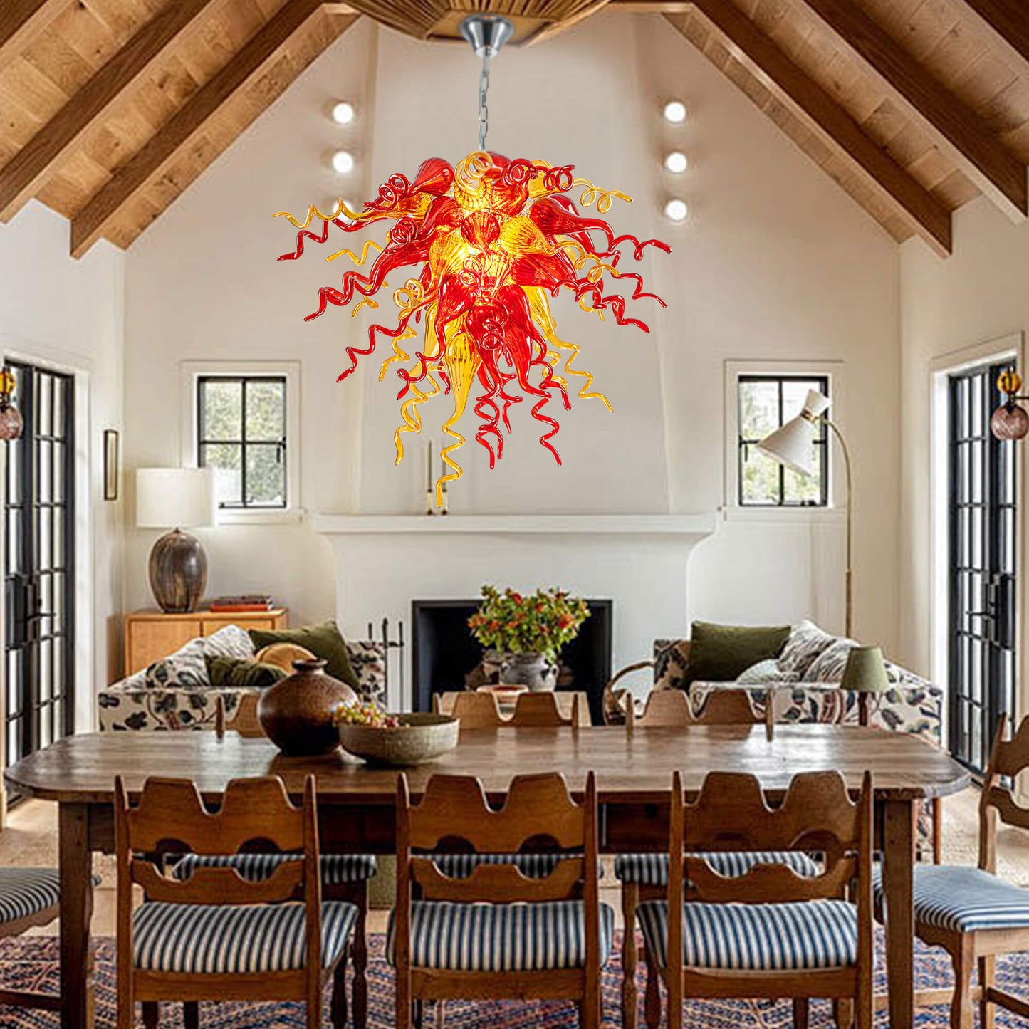 Red and Yellow Hand Blown Glass Chandelier in a rustic living and dining space with a high vaulted wooden ceiling.