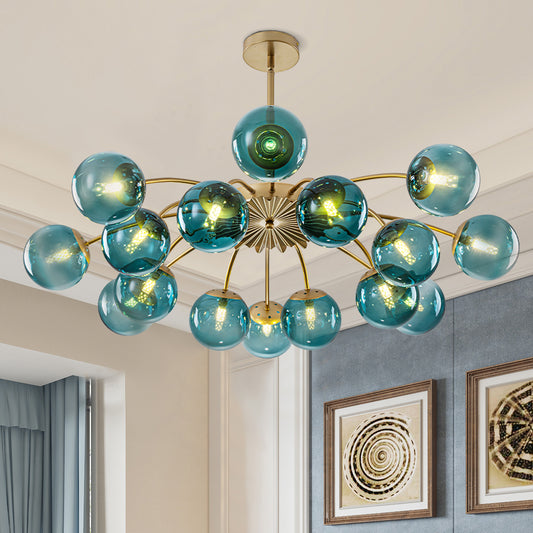 The 16-light teal glass globe chandelier casts a warm, inviting glow through its vibrant teal glass shades, elevating the cozy ambiance of any room.