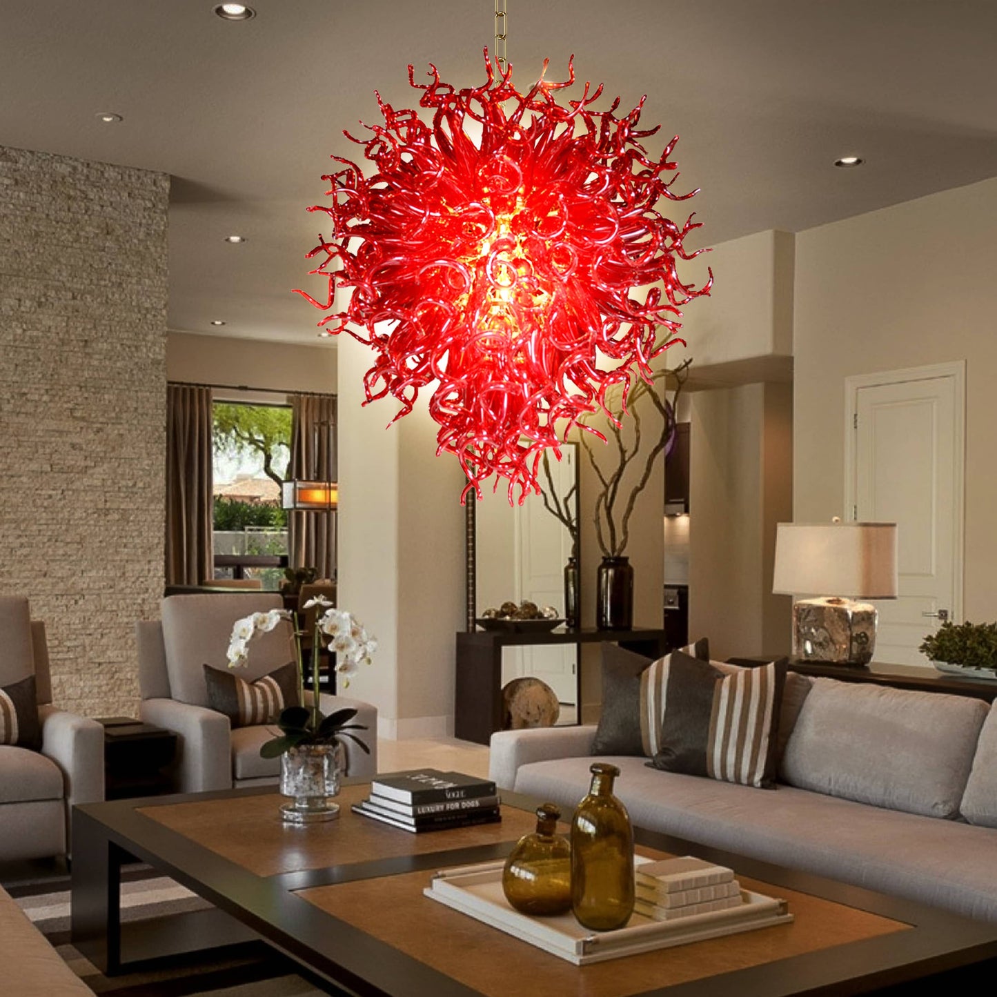 Daring ruby red hand blown glass chandelier in a sleek living room with dark countertops.