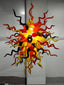 Eternal Flame blown glass chandelier featuring a dense sunburst of red, yellow, and black spiral glass tendrils lit from within.
