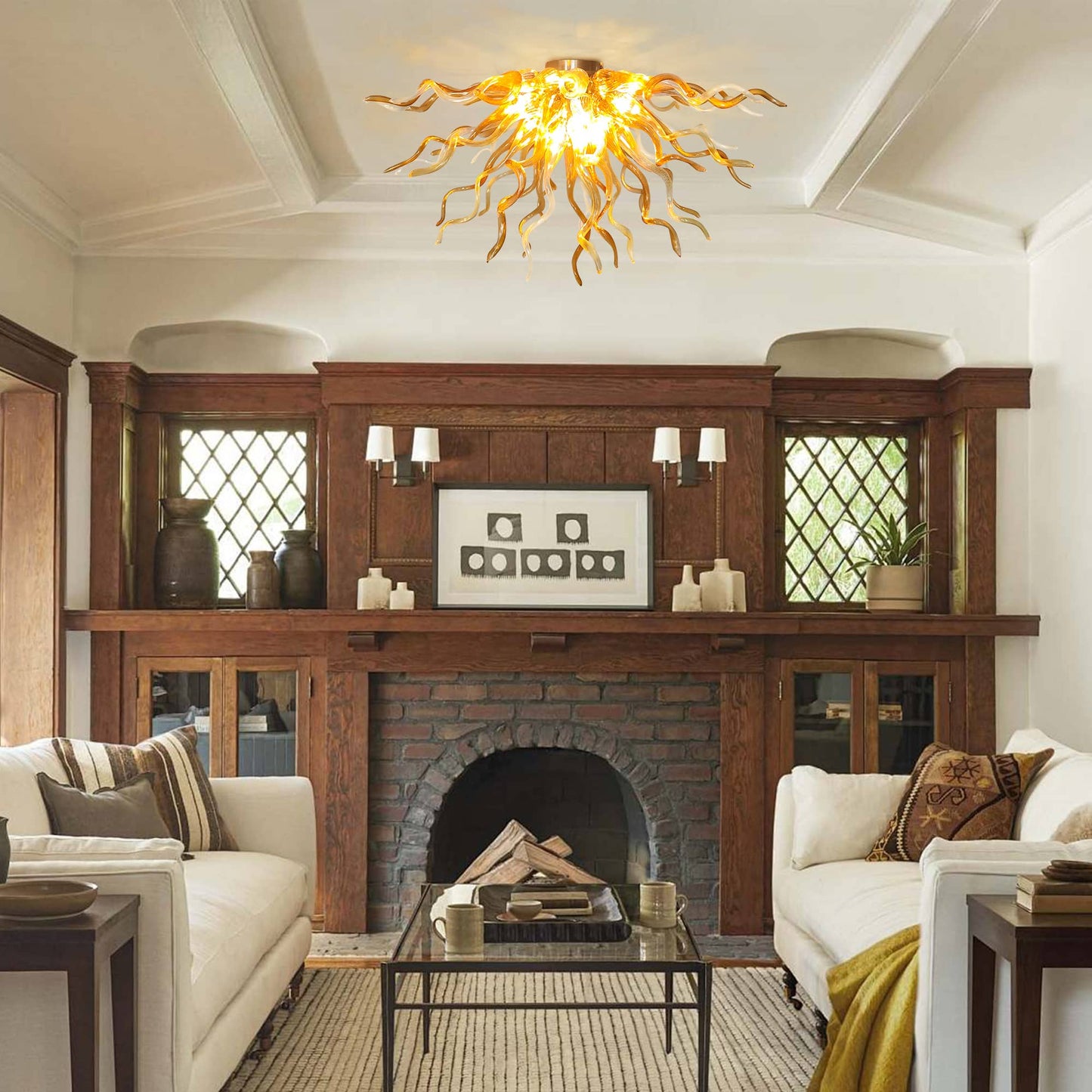 Warm, inviting living room design with the unique branching glass ceiling light fixture centered above a classic dark wood mantel fireplace and matching white sofas.