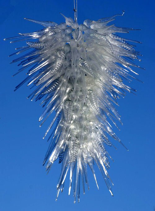 Detailed view of the crystalline glass chandelier against a bright blue sky background, highlighting the clarity of the artisan glass.