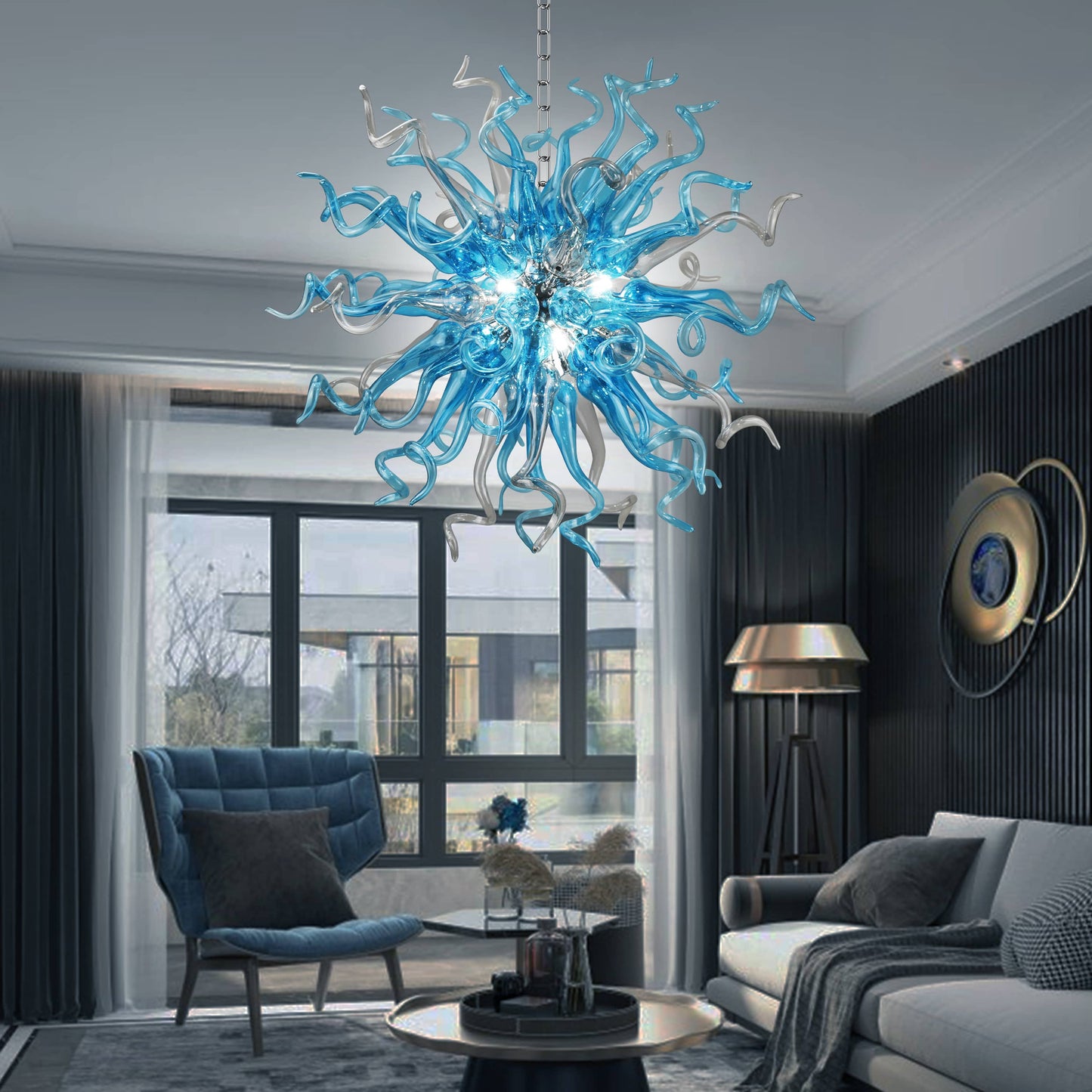 Modern living room with a blue glass chandelier, gray sofa, and armchair.