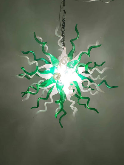 Artisan green and white glass chandelier illuminated in a modern interior setting, showing its vibrant radiant glow.