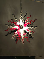 Modern chandelier with red, black, and white design on a plain background