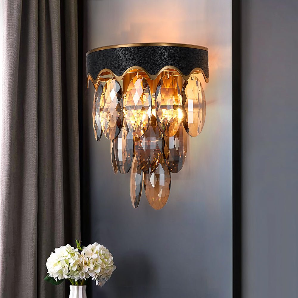 Modern luxury black and gold wall sconce with warm golden crystal glow.