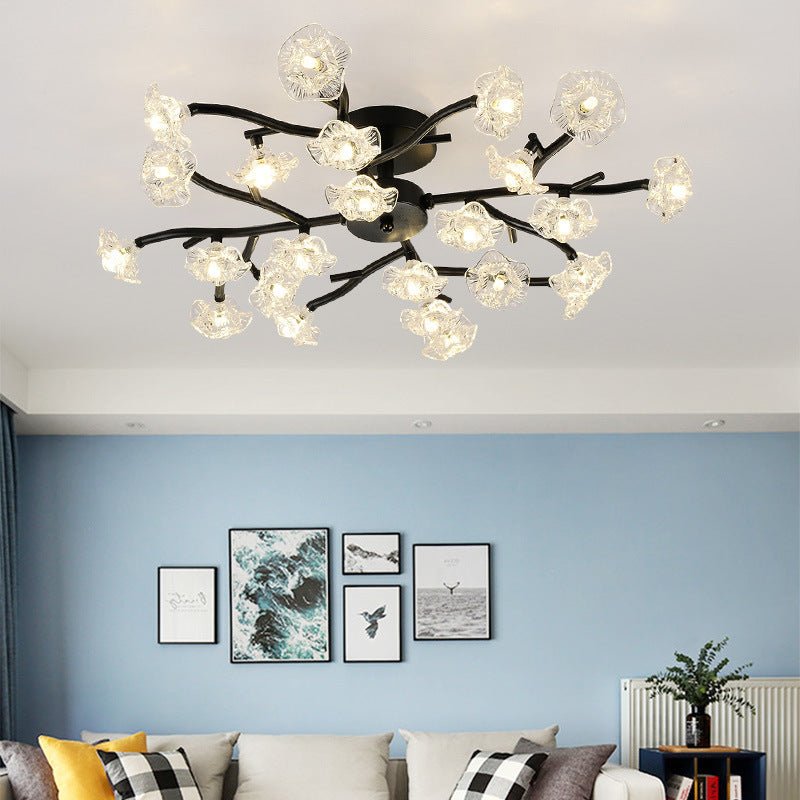 Elegant golden stem floral chandelier illuminating a contemporary dining area.