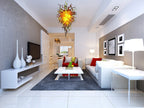 Minimalist luxury living room featuring the amber and yellow sculptural glass chandelier as a warm, artistic centerpiece.