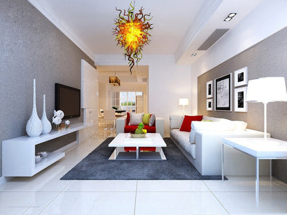 Minimalist luxury living room featuring the amber and yellow sculptural glass chandelier as a warm, artistic centerpiece.
