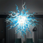 Large spherical hand-blown glass chandelier featuring an intricate web of cyan blue and translucent white glass tendrils against a dark background.
