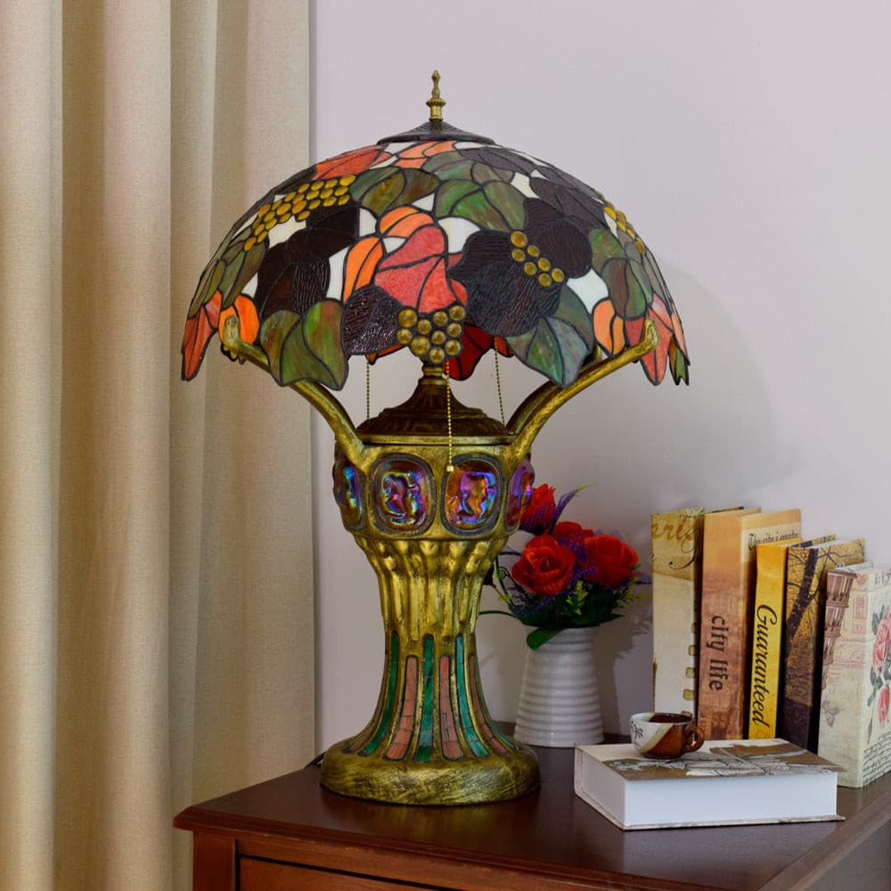 Vintage table lamp with glowing base and colorful leaf pattern