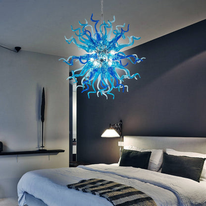 Modern bedroom interior featuring a vibrant blue glass Sputnik chandelier hanging above a large bed, serving as a dramatic focal point.