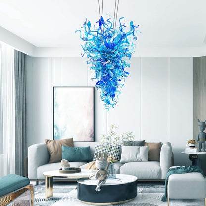 Modern minimalist living room featuring a sculptural blue glass chandelier above a grey sofa.