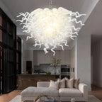 Modern open-concept living area with a grey sectional sofa illuminated by the radiant white sculptural pendant light.