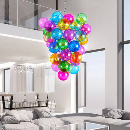 Modern open-plan living and dining area with a colorful blown glass bubbles chandelier as a playful focal point.