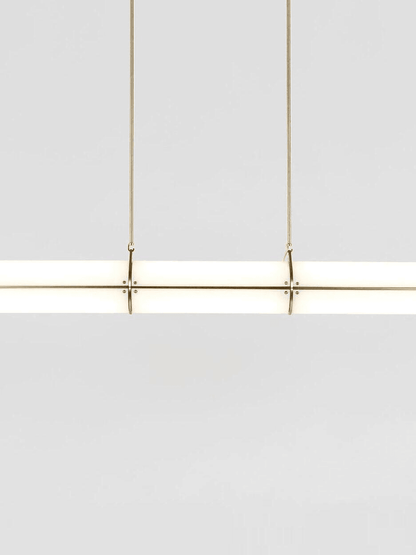 Modern white frosted glass cylinder pendant light with gold brass hardware detail view.