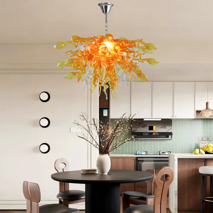 Golden and clear hand blown art glass chandelier providing ambient light in a chic dining area with a black table.