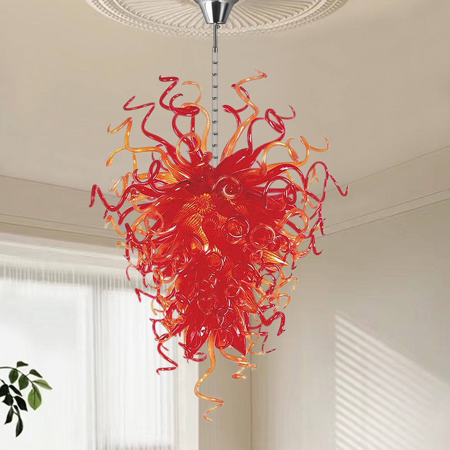 Modern hand blown art glass chandelier hanging in bright white living room.