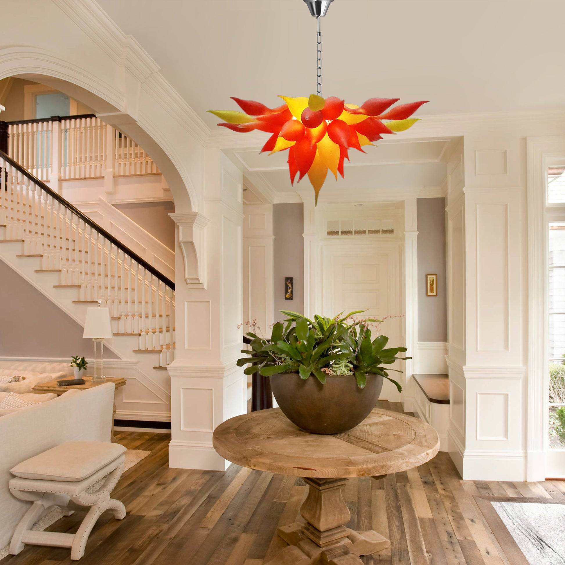 Red modern flower-shaped blown glass chandelier in traditional entryway.