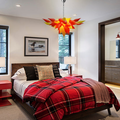 Red and orange petal  modern blown glass chandelier in cozy bedroom.
