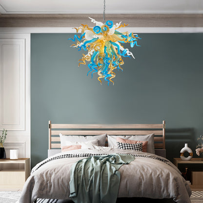 Modern blue and gold hand blown glass chandelier creating a sophisticated ambiance in bedroom.