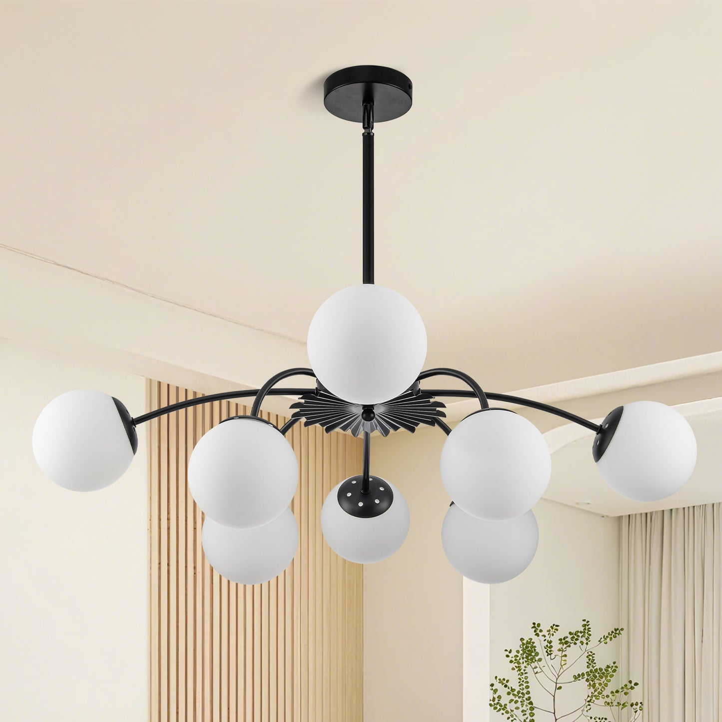 Unlit black 8-light frosted glass pendant globe chandelier in modern styled room.