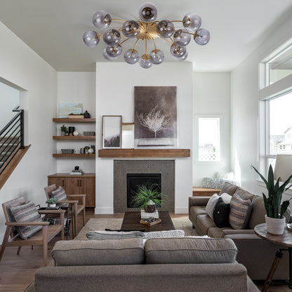 16-light smoky gray glass ceiling light in living room with stone fireplace & wooden floors.