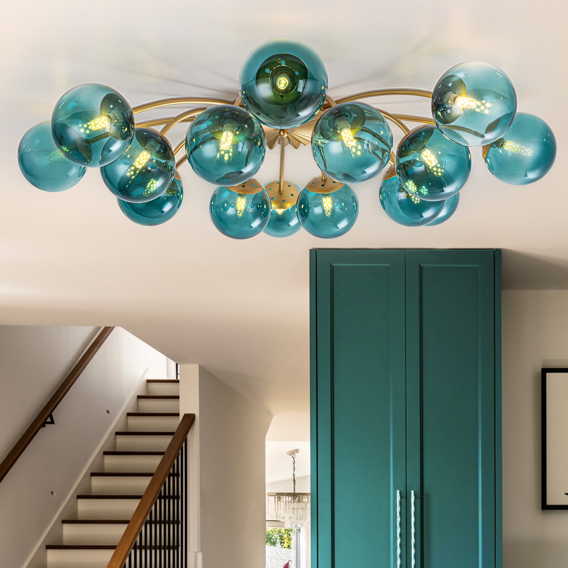 16-Light teal glass bubble globe ceiling light above staircase with teal cabinet accent.