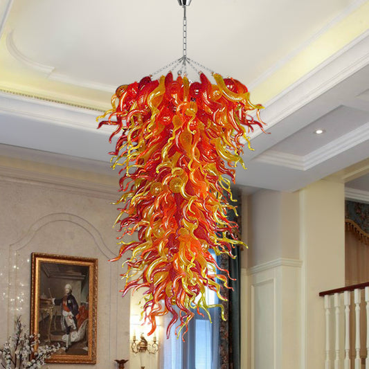 Close-up of the red, orange, and yellow cascading hand blown glass chandelier in a formal living or dining room setting.