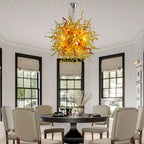 Chihuly-style blown murano glass chandelier installed in a sunlit dining room.