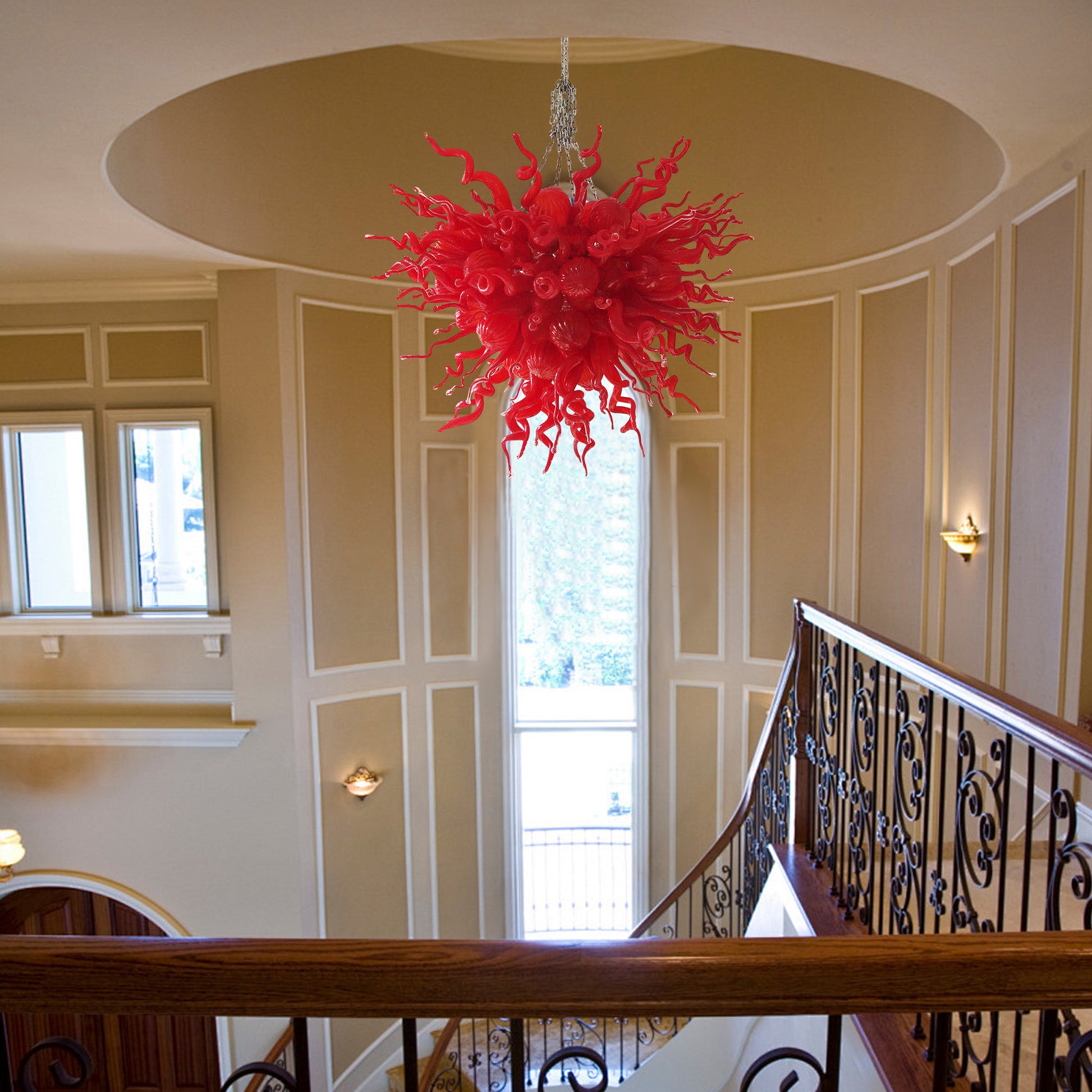 Red abstract hand blown glass sculpture functioning as a grand art chandelier in a luxury home.