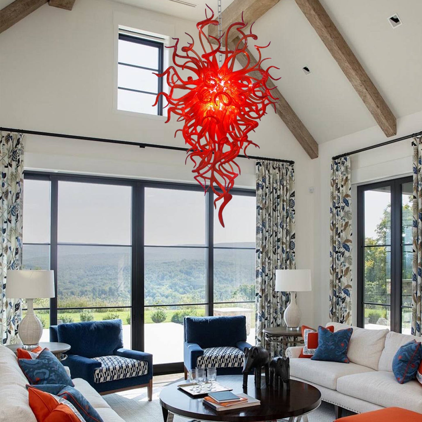 Vibrant red hand blown art glass chandelier in bright sunlit room with mountain views.