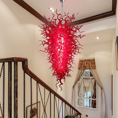 Crimson murano blown glass chandelier hanging in a multi-level stairwell, providing a stunning visual from top to bottom.