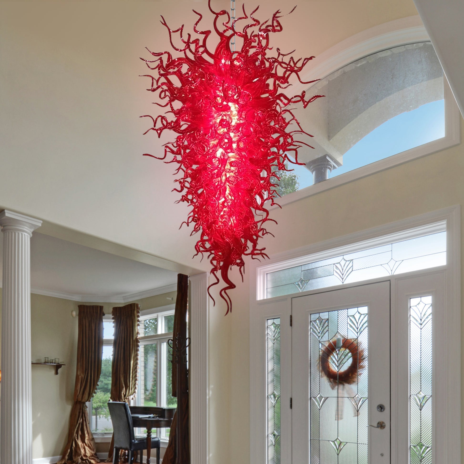 Artistic red murano blown glass chandelier illuminating a grand foyer.