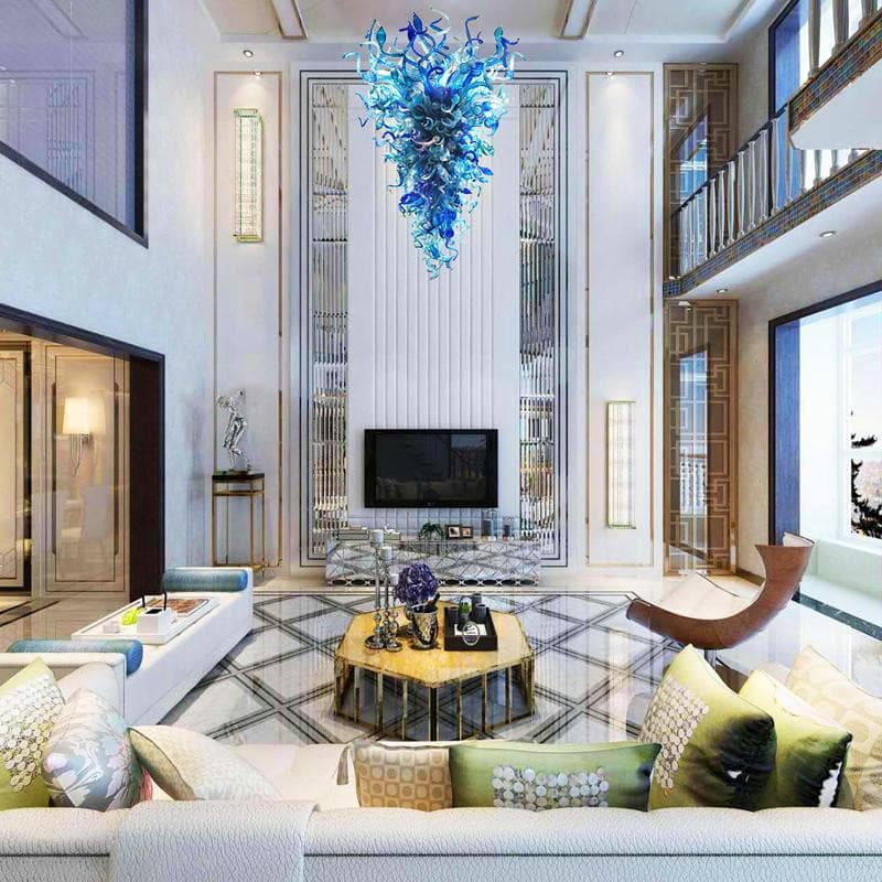 Striking blue blown glass chandelier in a modern double-height living room with a TV wall and balcony.