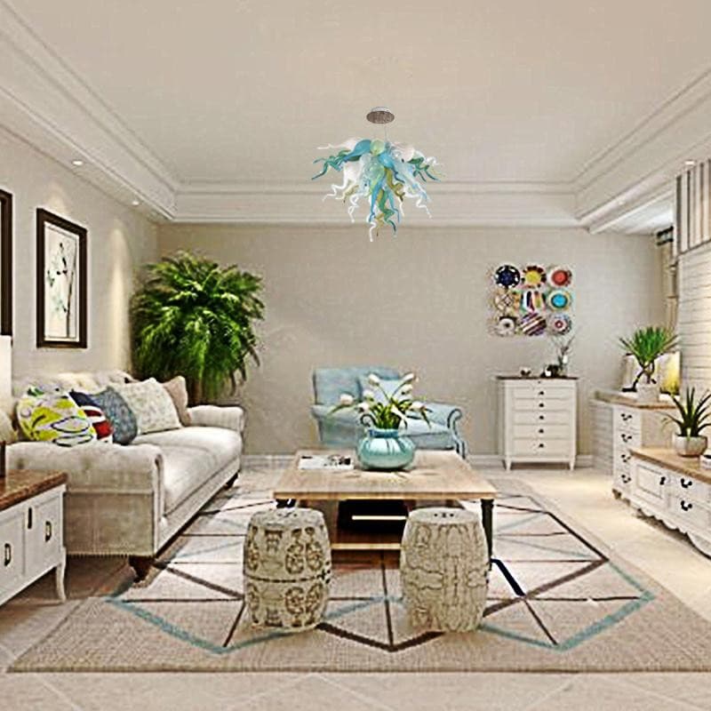 Wide view of a luxury modern living room with high ceilings illuminated by a handcrafted sea-tone glass chandelier.
