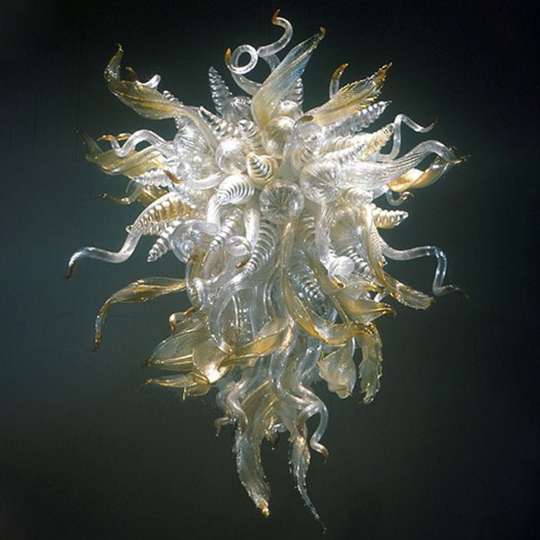 Detailed studio shot of a clear and gold Murano style blown glass chandelier with elegant twisted horn and leaf elements.