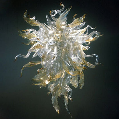Detailed studio shot of a clear and gold Murano style blown glass chandelier with elegant twisted horn and leaf elements.