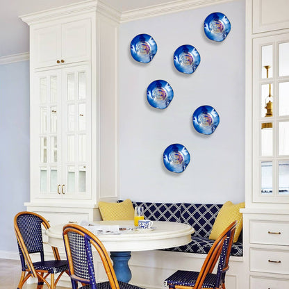 Vibrant blue glass wall flowers displayed in a bright kitchen breakfast nook with white cabinetry.