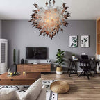 Modern living room with a chandelier, TV, and home office setup.