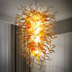 Close-up of Sun Flare hand-blown glass chandelier with vibrant orange and amber spiral glass tentacles, luxury artistic lighting.