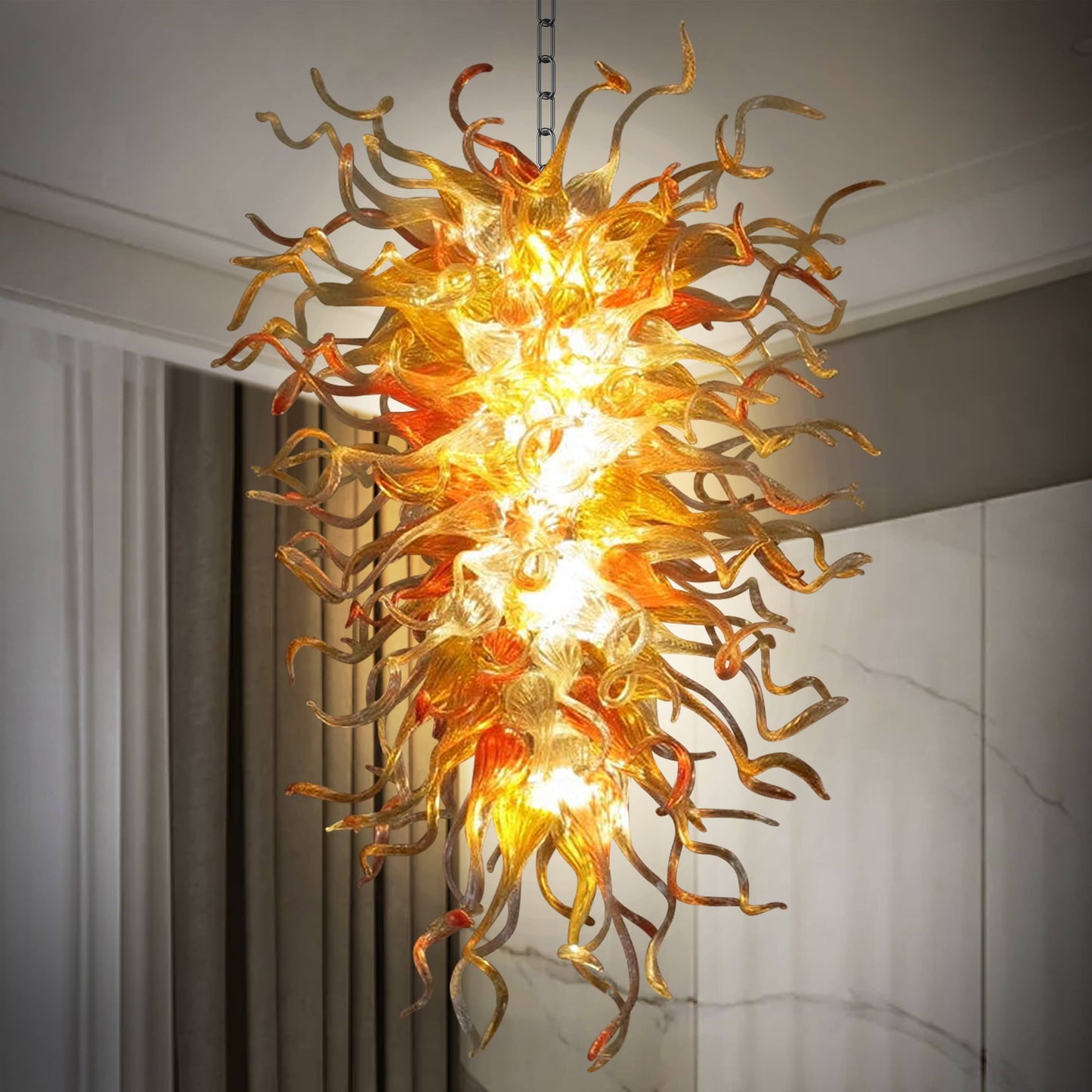 Close-up of Sun Flare hand-blown glass chandelier with vibrant orange and amber spiral glass tentacles, luxury artistic lighting.