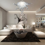 Luxury modern white living room with a large sectional sofa, featuring a clear sculptural glass chandelier as a sophisticated focal point.