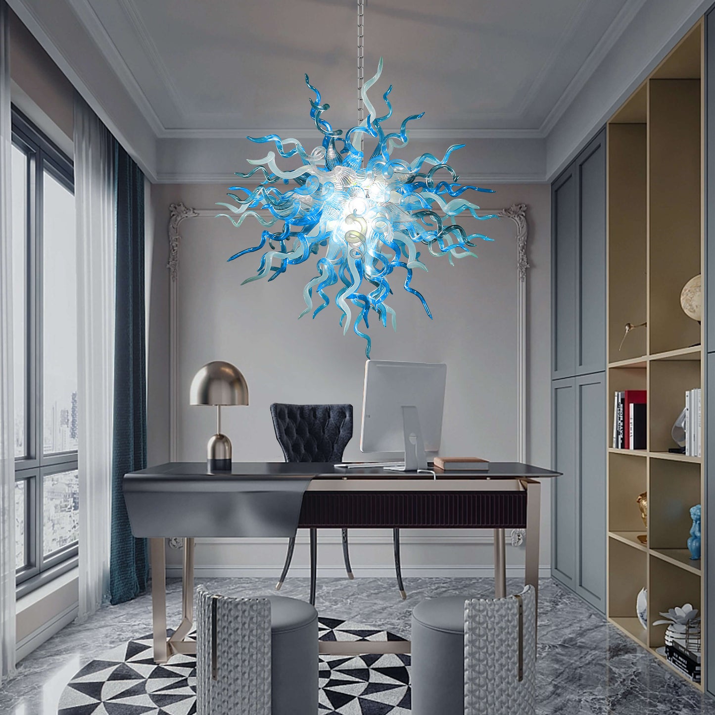 Modern office with a blue and white blown glass chandelier, desk, and computer setup.