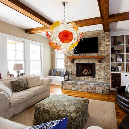 A rustic-modern living room with a stone fireplace, wood beams, and a unique sculptural glass chandelier.