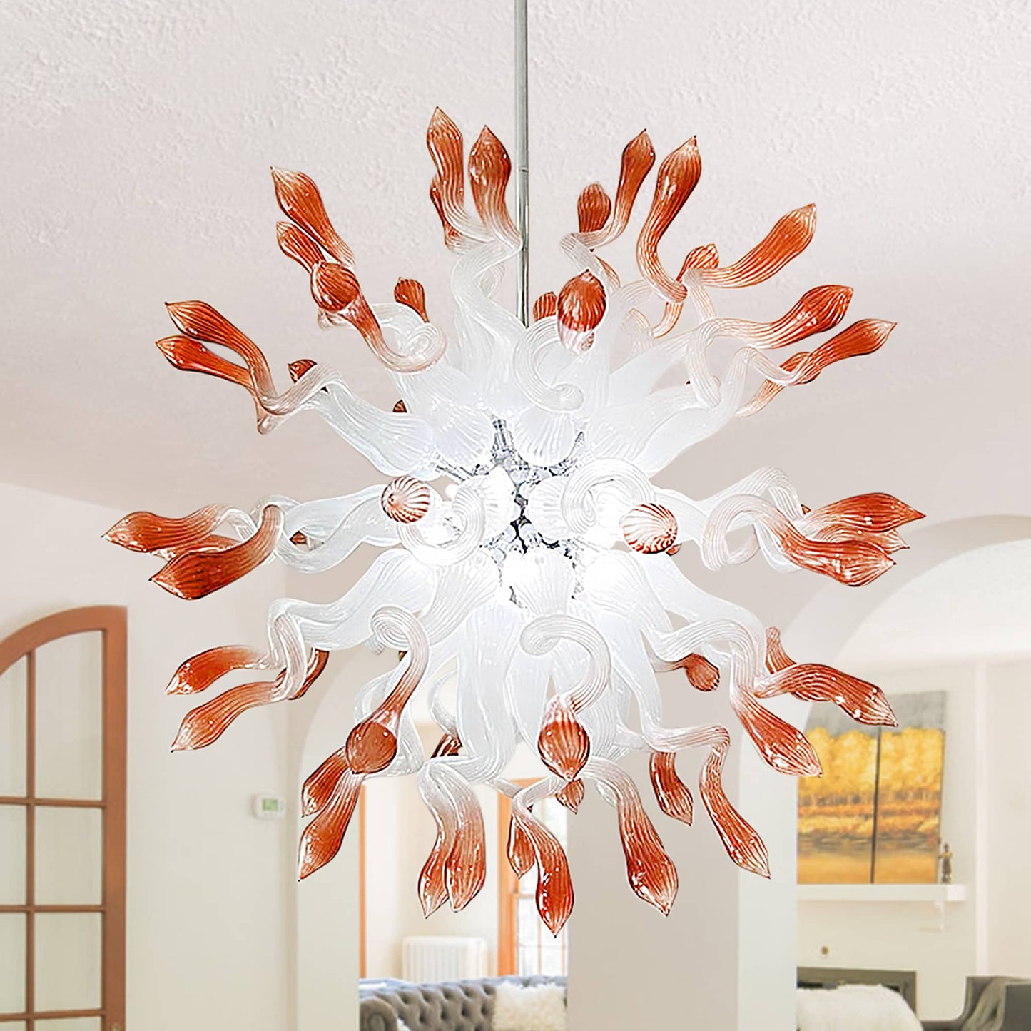 Close-up view of the  hand-blown glass chandelier featuring twisted translucent white arms with distinct coral and amber glass tips in a starburst pattern.