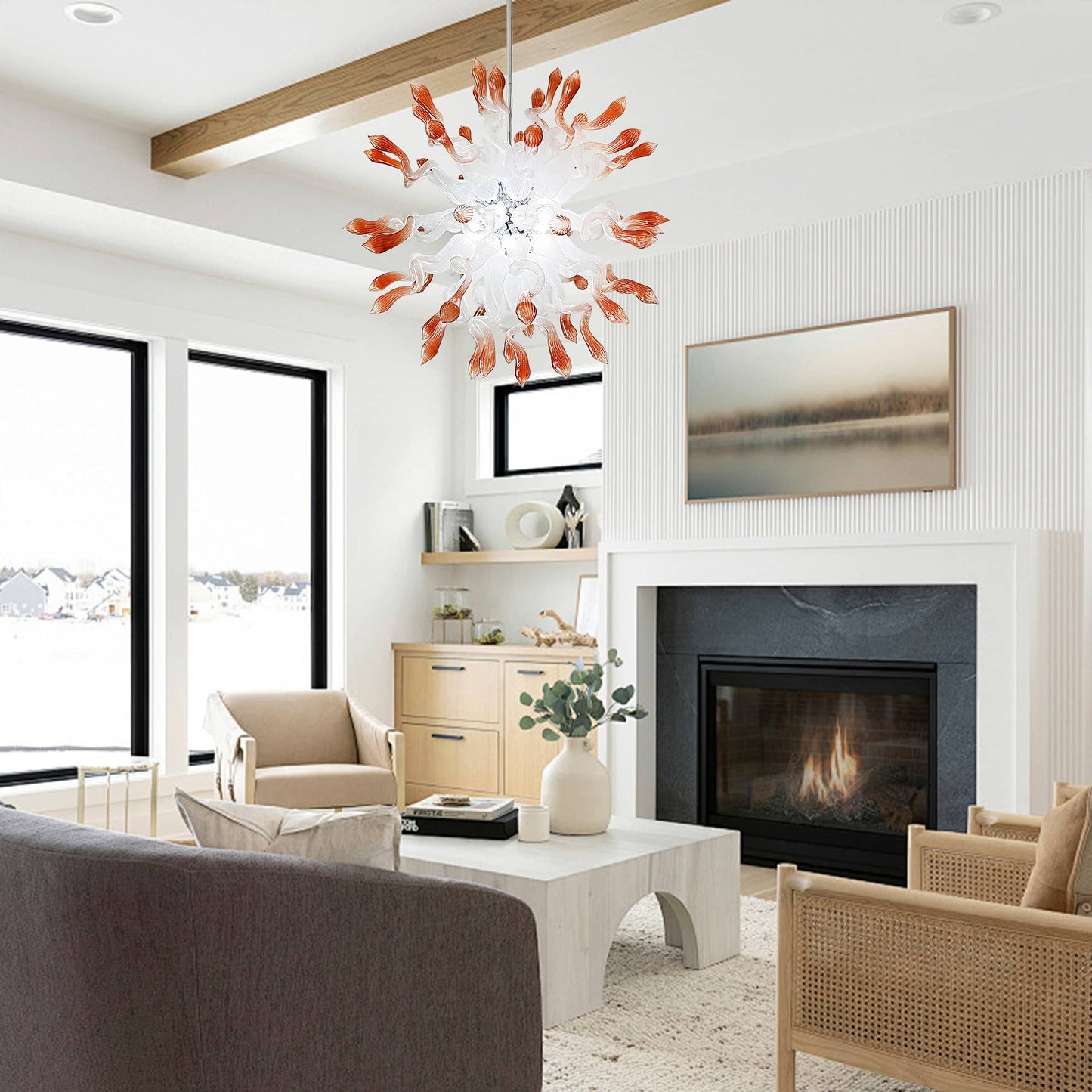 Interior view of a modern living room with a stone fireplace and vaulted ceilings, showcasing the hand-blown starburst chandelier as a central ceiling fixture.