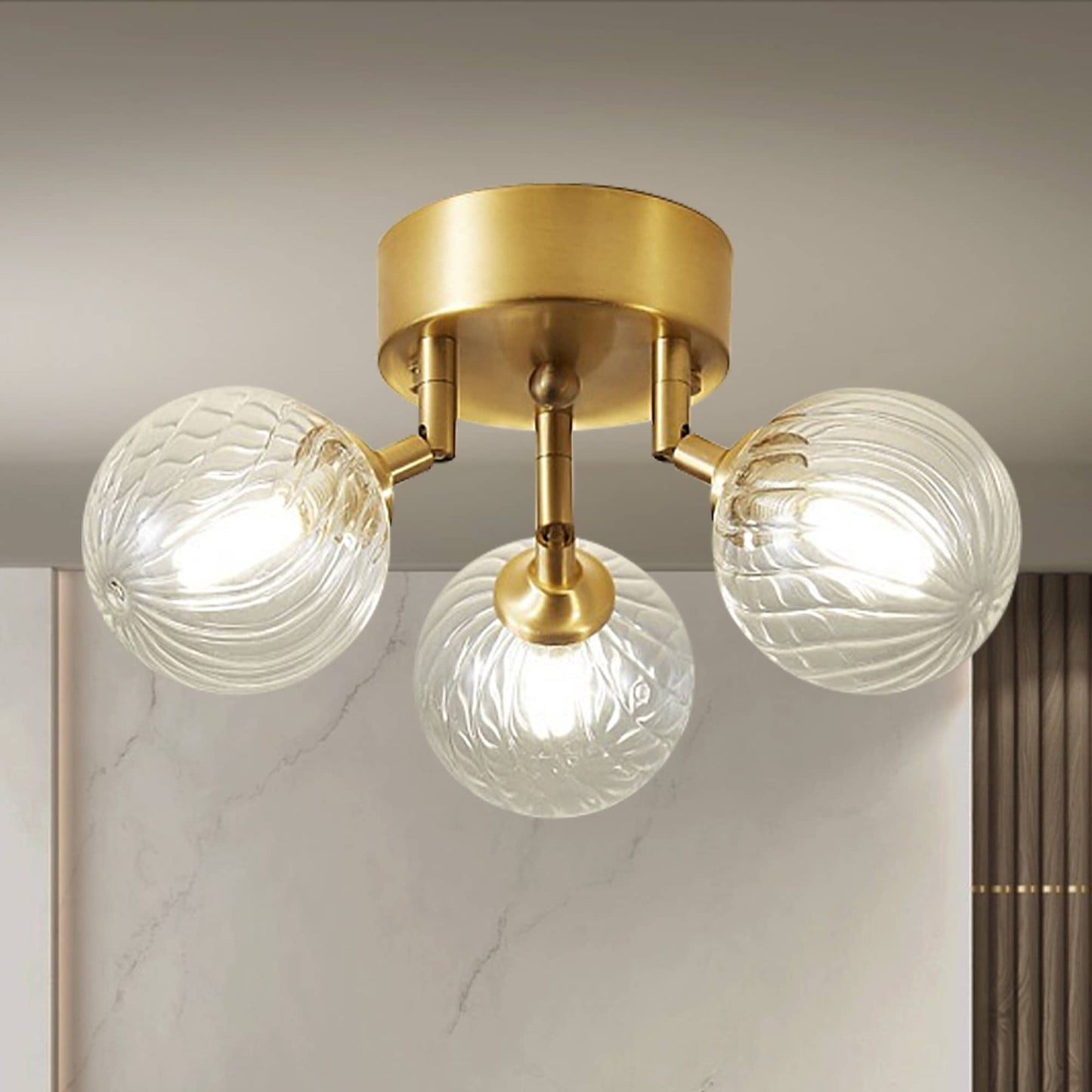 Side profile of the brass ceiling light, highlighting the three-light arrangement and the intricate ribbing of the glass balls.