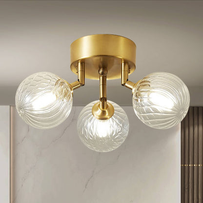 Side profile of the brass ceiling light, highlighting the three-light arrangement and the intricate ribbing of the glass balls.