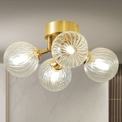 Side profile of the brass ceiling light, highlighting the three-light arrangement and the intricate ribbing of the glass balls.